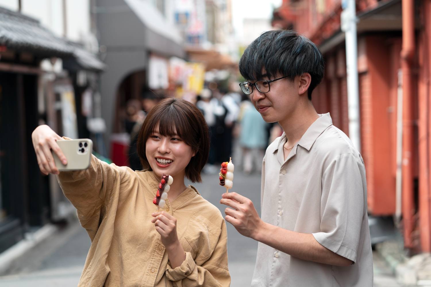 Couple taking a selfie with dango in a Japanese street
